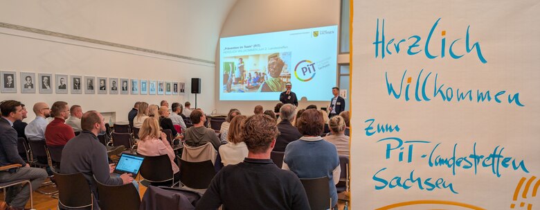 In der Collage ist links ein zahlreiches Publikum, dass zu den Referierenden nach vorne schaut und rechts ein Flipchart zur Begrüßung beim PiT-Landestreffen Sachsen.