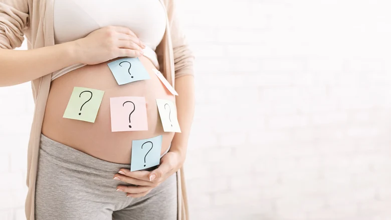 Auf der linken Seite ist ein Torso einer Schwangeren, welche ihr Babybauch umfasst. Darauf kleben zudem bunte Klebezettel mit Fragezeichen.