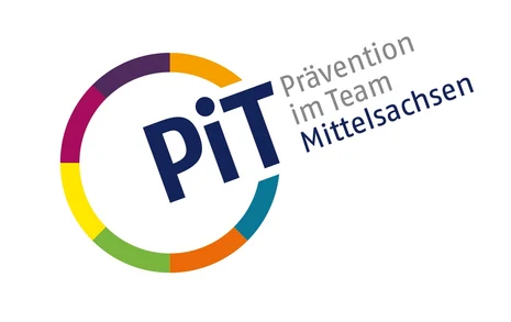 Links ist ein Kreis mit bunten Umrissen. An einer Stelle ist dieser unterbrochen und dort steht "PiT". Neben dem Kreis steht zudem "Prävention im Team" in grauer Schrift und darunter "Mittelsachsen" in blauer Schrift.