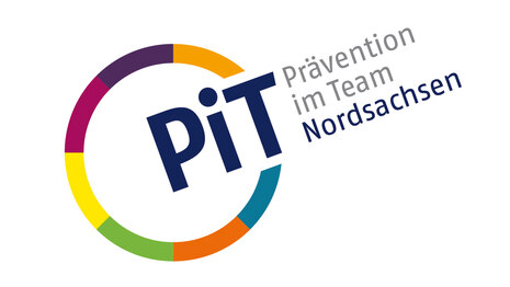 zeigt buntes kreisförmiges PiT Logo mit grauer Aufschrift: Prävention im Team Sachsen