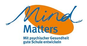 Im Hintergrund ist ein Oval in orangener Farbe, welcher diagonal ausgerichtet ist. Im Vordergrund steht in blauer FArbe "Mind Matters". Darunter steht weiterhin in kleinerer Schriftgröße "Mit psychischer Gesundheit gute Schule entwickeln".